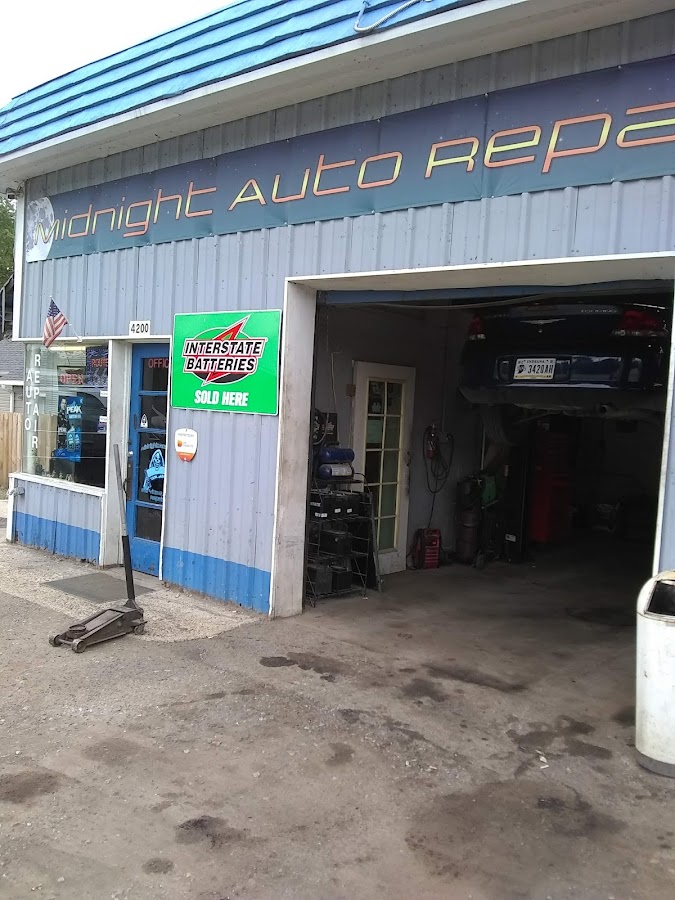 Midnight Auto Repair shop storefront with sign and open garage bay